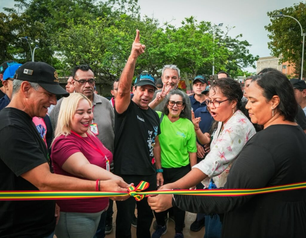 Espacio público renovado con zona de juegos infantiles, gimnasio al aire libre y zonas verdes bajo un puente en el barrio El Recreo, Barranquilla.