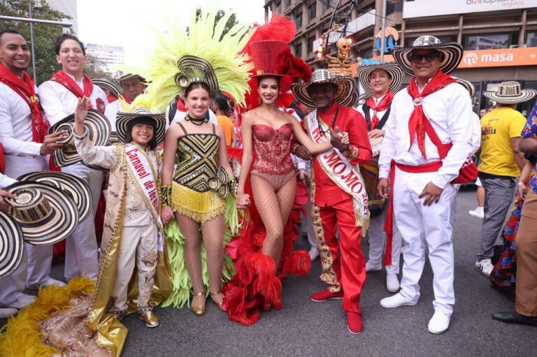Delegación de artistas con trajes típicos del Carnaval de Barranquilla desfilando por una avenida de Madrid.